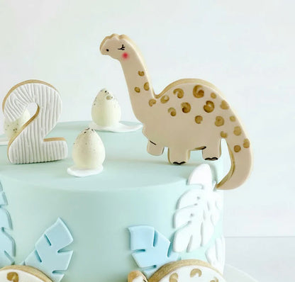 Dinosaur children's birthday cake in a buttercream cake with hand painted edible dinosaurs decorations 