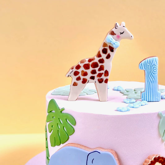 Safari buttercream children's cake with giraffe, lion and elephant edible handcrafted decorations. 